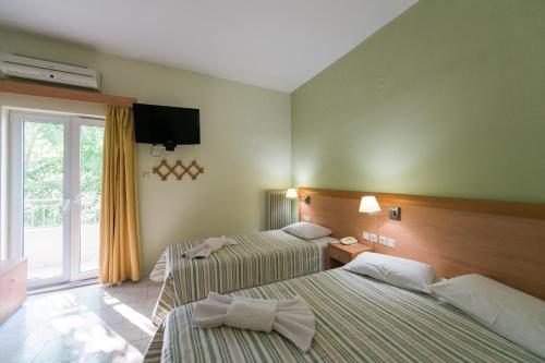 a hotel room with two beds and a window at Plaz Hotel in Selianitika