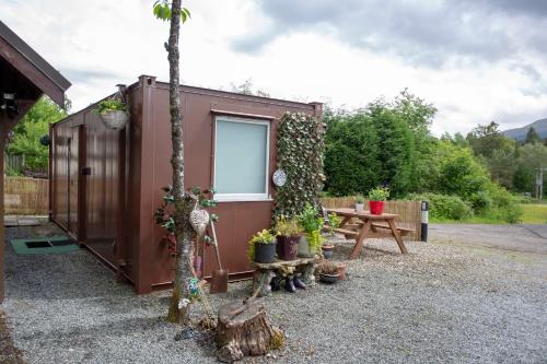 a tiny house with a picnic table and a tree at Room with a view in Spean Bridge