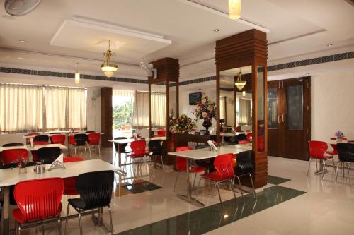a dining room with tables and red chairs at Vinay Residency in Sindhnūr