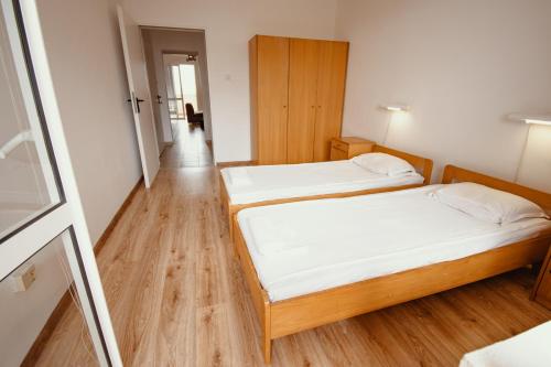two beds in a small room with a hallway at Holiday Village Ravda (Ваканционно селище Равда) in Ravda