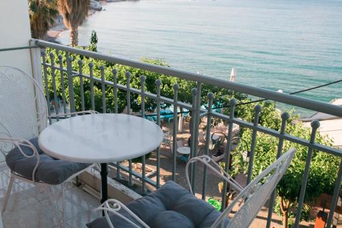 a table and chairs on a balcony overlooking the water at Plaz Hotel in Selianitika