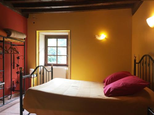 una camera con un letto in una stanza con una finestra di La Chambre des Buissonnats a Martailly-lès-Brancion