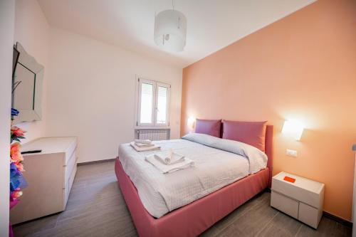 1 dormitorio con 1 cama grande y paredes de color naranja en House Giardina, en Cefalú