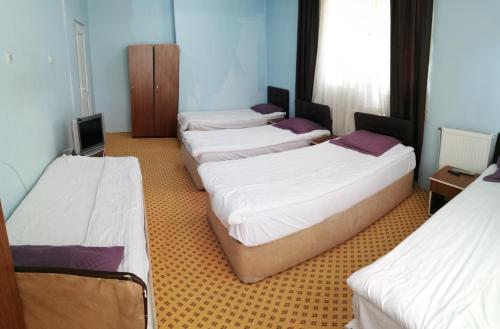 a group of four beds in a room at Esin Pansiyon in Tokat