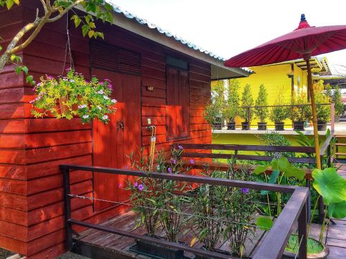 a house with a wooden door and some plants at Mango House in Sukhothai