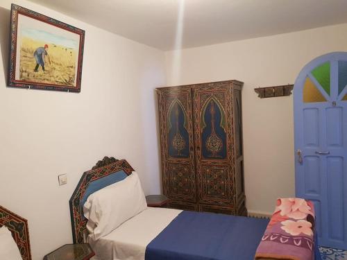 a bedroom with a bed and a blue door at Hotel Ouarzazate in Chefchaouene