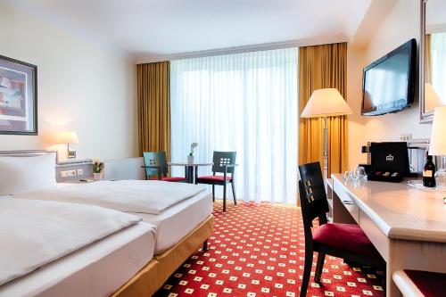 a hotel room with a bed and a table and chairs at Welcome Hotel Bad Arolsen in Bad Arolsen