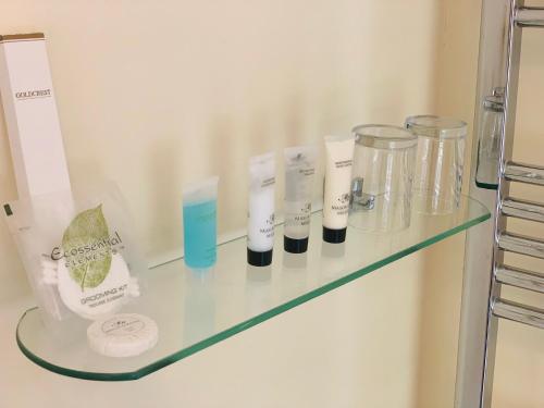 a glass shelf in a bathroom with some items on it at Bridge View Guest House in Ironbridge
