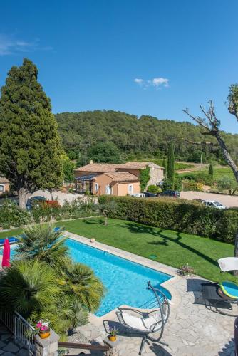 une piscine avec 2 chaises longues et une maison dans l'établissement Chateau de Sainte Croix, à Carcès