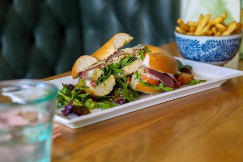 a sandwich and salad on a plate with a bowl of fries at Beck Hall in Malham