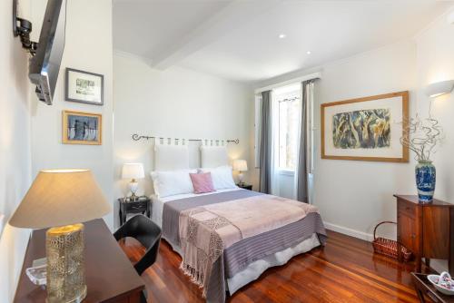 a bedroom with a bed and a table with a lamp at Dousmani Corfu Old Town Studio Suite in Corfu Town