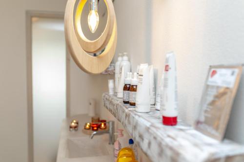 a bathroom counter with bottles ofodorizers and a mirror at Cycladic Islands Hotel & Spa in Agia Anna Naxos