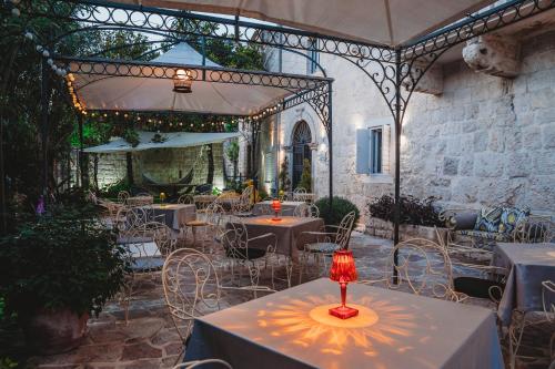 a dining room with a table, chairs, and a fire place at Palazzo Radomiri Heritage Boutique Hotel in Kotor