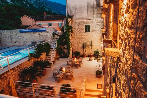 a balcony with tables and chairs next to a pool at Palazzo Radomiri Heritage Boutique Hotel in Kotor