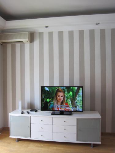 a flat screen tv sitting on top of a white cabinet at Knez Mihailova, Beograd in Belgrade