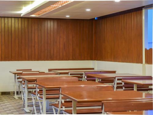 an empty classroom with wooden tables and chairs at Kensington Suites in Bengaluru