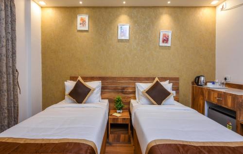 a hotel room with two beds and a sink at Kensington Suites in Bengaluru