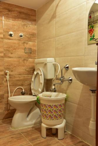 a bathroom with a toilet and a sink at Elegant Serviced Apartment in Mysore