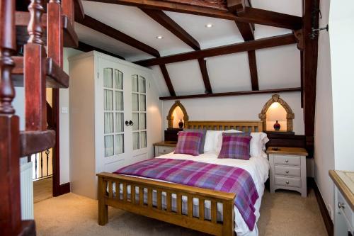 a bedroom with a large bed with a wooden frame at The Old School - Beautiful School House, quiet location near the coast in Laugharne