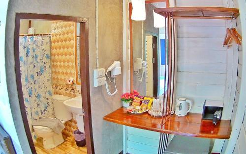 a small bathroom with a sink and a toilet at Mango House in Sukhothai