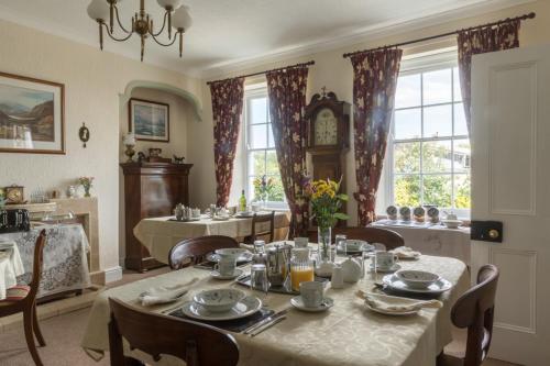 uma sala de jantar com mesa e cadeiras e um relógio em Hardwick Farm em Abergavenny
