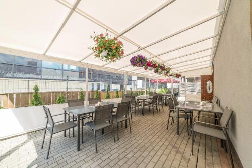 an outdoor patio with tables and chairs and flowers at Hostel Filip in Gdańsk