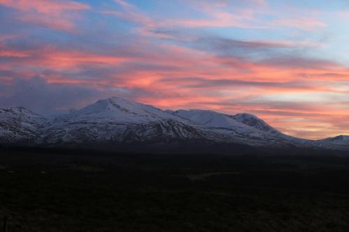 a snow covered mountain with a sunset in the background at Room with a view in Spean Bridge