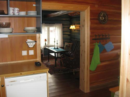 une cuisine avec une porte s'ouvrant sur une salle à manger. dans l'établissement Gamlestugu hytte, à Al