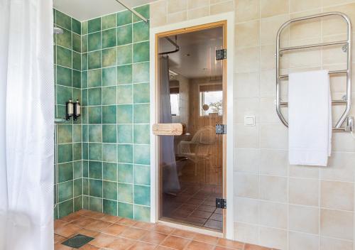 a bathroom with a shower with green tiles at Stufvenäs Gästgifveri in Söderåkra