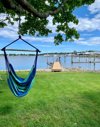 a hammock hanging from a tree next to a body of water at Harbor View Landing in Mystic