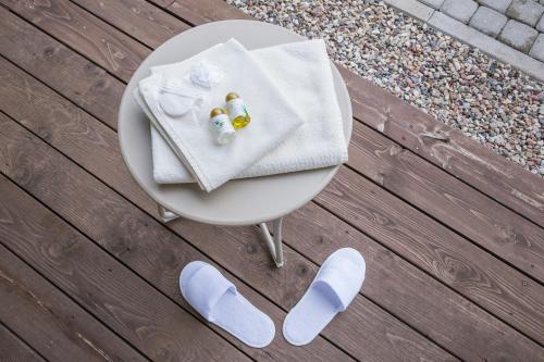 Amatciems的住宿－Dzeņi，一张带毛巾和两瓶毛巾的白色桌子
