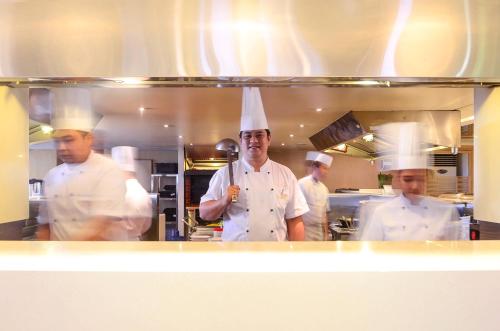 a group of chefs standing in a kitchen at Midas Hotel and Casino in Manila