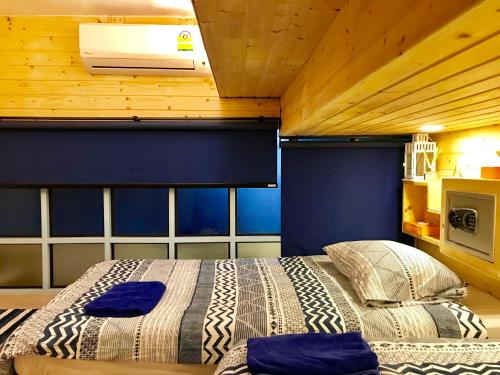 een slaapkamer met een bed en een blauwe muur bij Blu Cabin Gay Poshtel in Bangkok