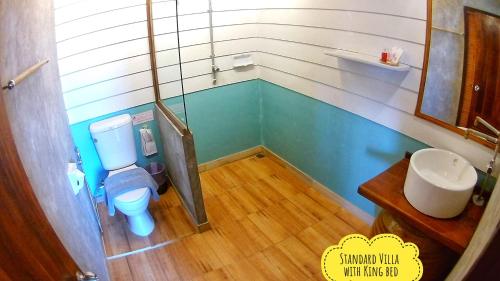 a small bathroom with a toilet and a sink at Mango House in Sukhothai