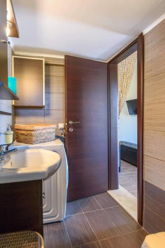 a bathroom with a sink and a wooden door at Poppy flower in Stalís