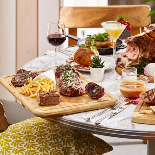 a table with meat and french fries and a glass of wine at Mama Shelter Toulouse in Toulouse