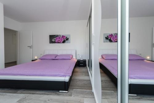 2 Betten in einem Zimmer mit lila Bettwäsche in der Unterkunft Villa Barbara-holiday home with sea view in Zadar