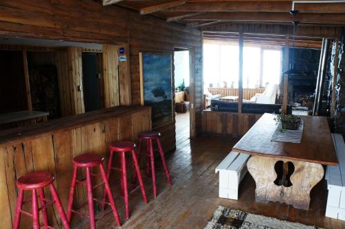 un bar avec quatre tabourets rouges dans une pièce dans l'établissement Cordillera Hostel, à Farellones