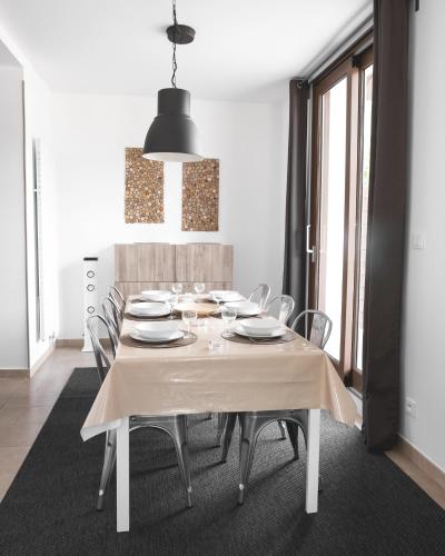 a dining room with a white table and chairs at Au chalet des quatre saisons in Ax-les-Thermes