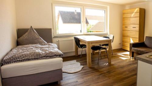 a bedroom with a bed and a desk and a table at Pension zum Hecht in Schemmerberg