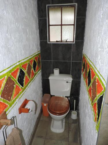 a small bathroom with a toilet and a window at Kruger Inn Backpackers in Marloth Park
