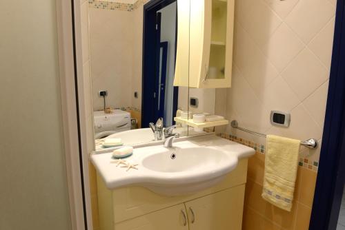 y baño con lavabo blanco y espejo. en Appartamento La Poesia Luxury - MyHo Casa, en Tortoreto Lido