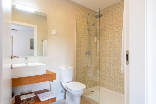 a bathroom with a toilet and a sink and a shower at Casa d'Amares in Amares