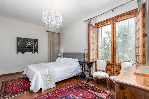 a bedroom with a bed and a desk and a chandelier at Alquería Calatrava B&B in Burriana