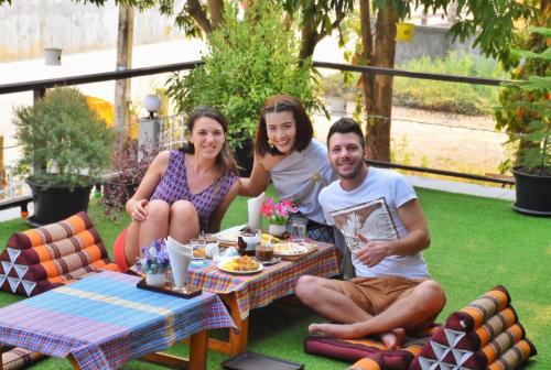 a group of three people sitting around a table at Mango House in Sukhothai