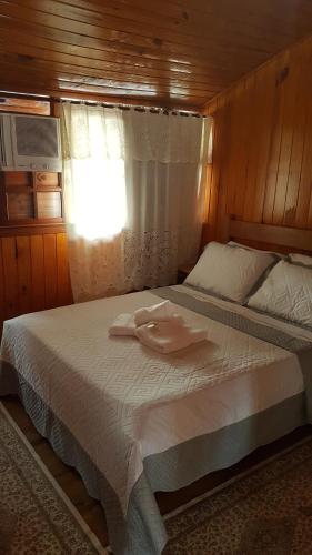 a bedroom with a bed with a towel on it at Pousada Bem Te Vi Lumiar in Lumiar