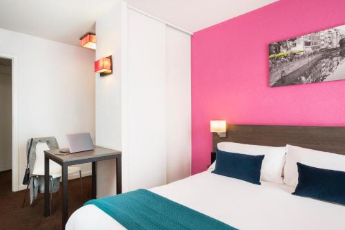 Cette chambre comprend un lit et un bureau avec un ordinateur portable. dans l'établissement Aparthotel Adagio Access Strasbourg Petite France, à Strasbourg