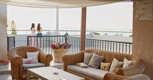 a balcony with two chairs and a couch and a table at Waterlily Hotel Apartments in Kalathas