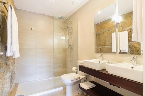 a bathroom with a sink and a toilet and a shower at Casa d'Amares in Amares