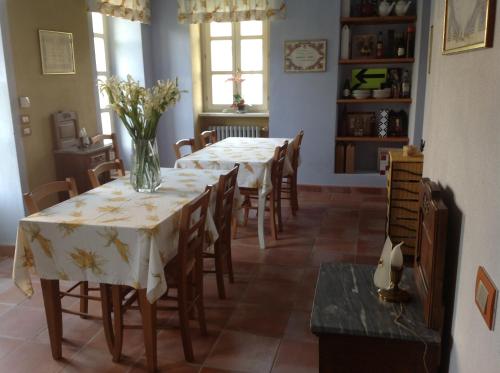 a dining room with tables and chairs with flowers on them at Locanda San Lorenzo in Roddino